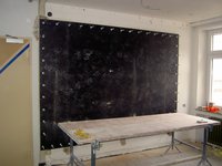 Zuerst wird die Wandscheibe, auf der sich das Gemälde befindet, beidseitig mit Siebdruckplatten verspannt. Dies dient zum einen dem Gemälde selbst als Schutz, als auch der Stabilisierung des Mauerwerks.
